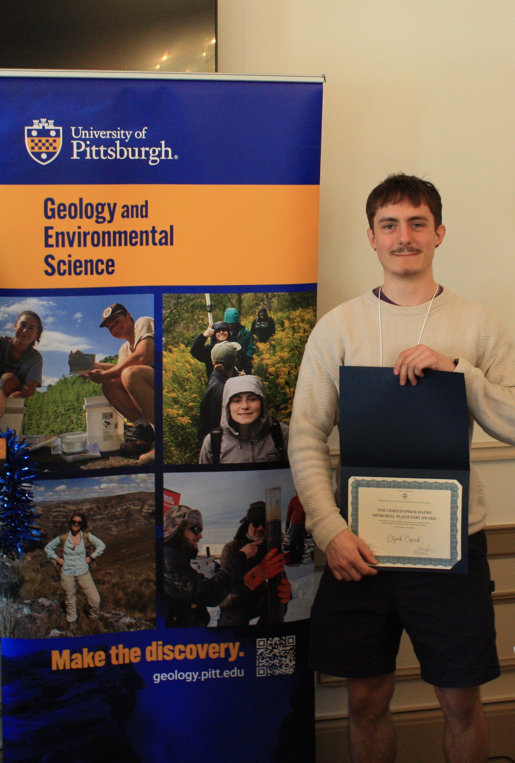 Image of student holding an award.