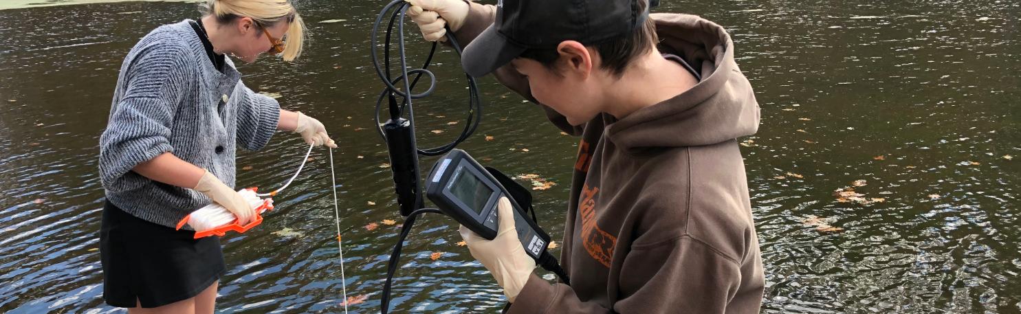 Two students sampling water for tests.